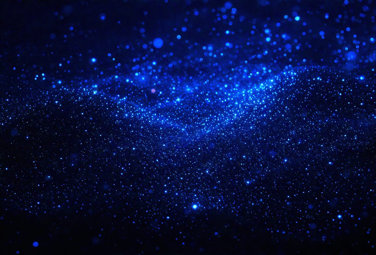 The primary subject of the image is a blue starry sky. The setting is a dark, star-filled night sky, with the stars being the main objects in the scene. The visual style is a photo, capturing the beauty of the night sky. The colors and mood of the image are predominantly blue, creating a serene and peaceful atmosphere.