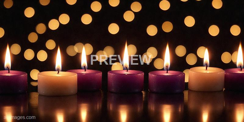 The image features a row of seven lit candles with pink and white wax, placed on a reflective surface. The background is filled with numerous out-of-focus warm yellow bokeh lights, creating a cozy, festive atmosphere. The flames of the candles flicker softly, casting gentle reflections on the surface below.