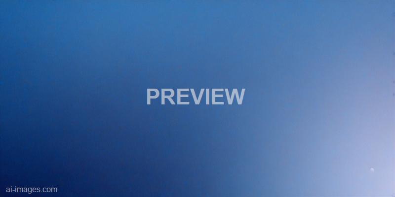 The image shows a clear sky transitioning from a deep blue on the left to a lighter blue on the right, indicating a possible sunset or sunrise. A small, faint moon or planet is visible in the lower right corner, adding a subtle celestial element to the scene.